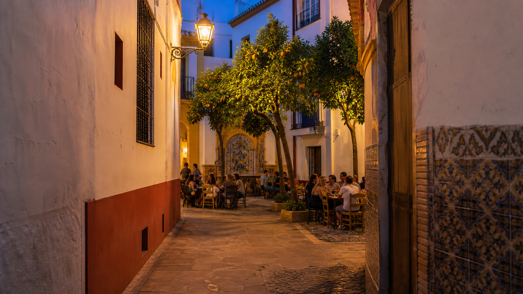 warme Sevilla-Gasse mit Orangenbäumen, Tapas-Tischen und ruhigem Abendlicht mit Fokus auf Orientierung und ruhige Planung.