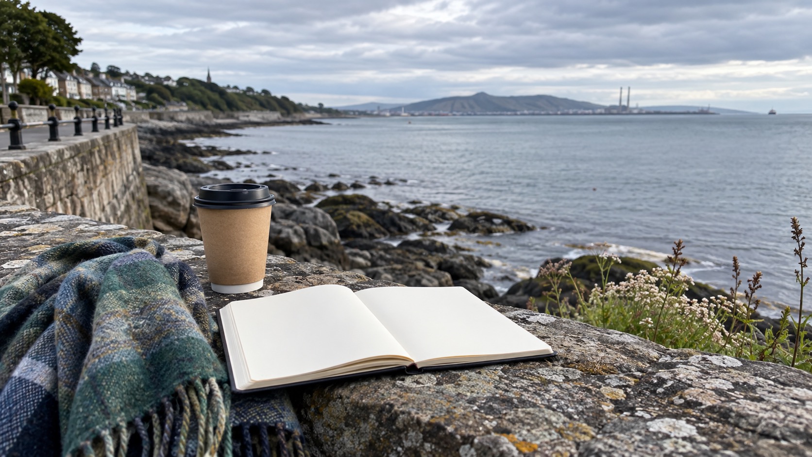 Dublin Küstenweg mit leerem Notizbuch, Schal und Blick auf die Bucht