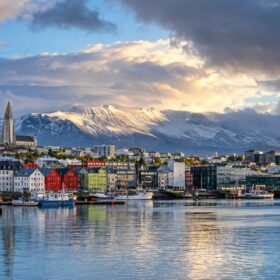Reykjavík mit bunten Häusern, Hafen, Bergen und wechselhaftem Island-Himmel