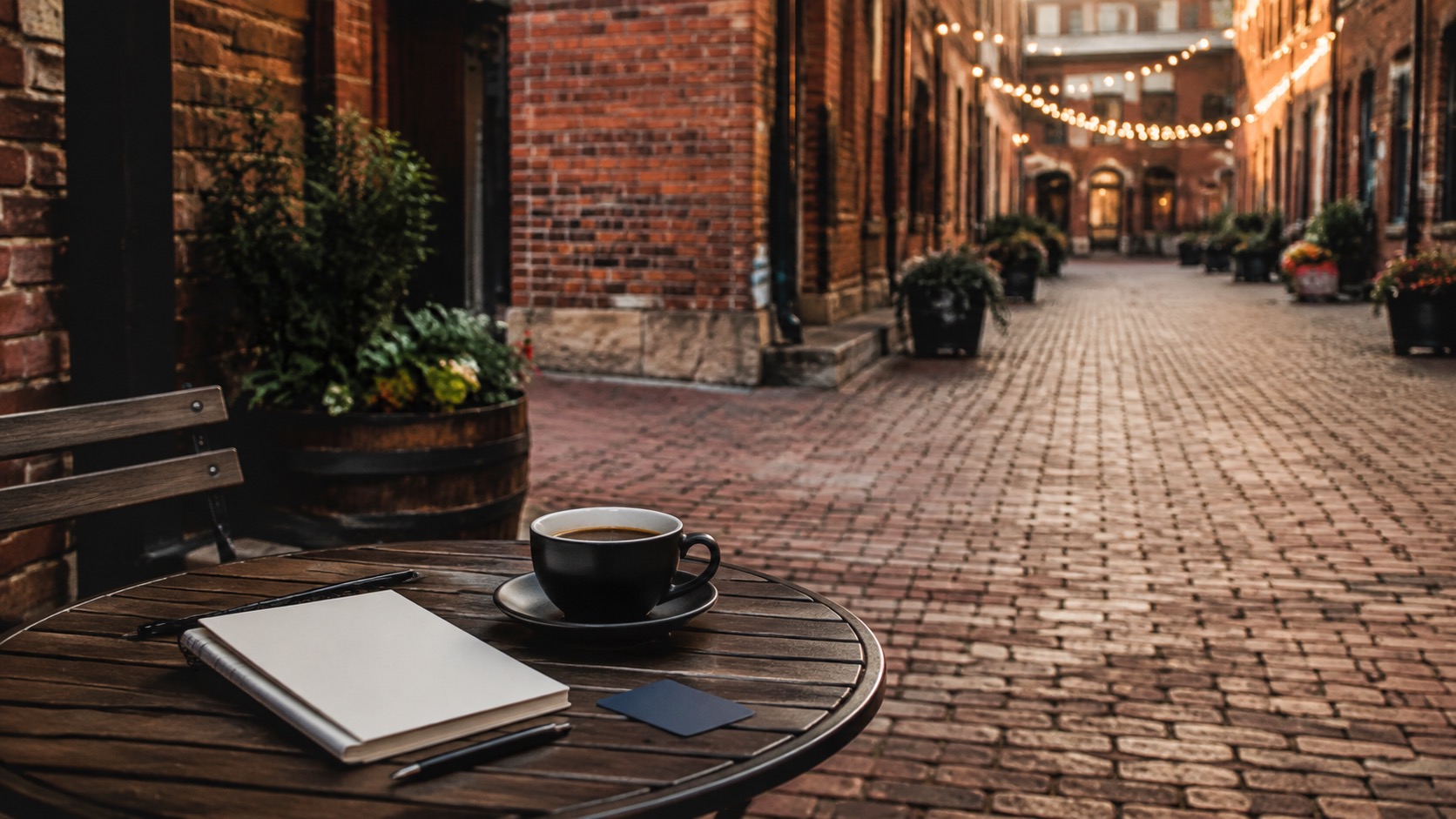 Backstein-Gasse in Toronto mit Kaffee, leerem Notizbuch und ruhigem Planungstisch